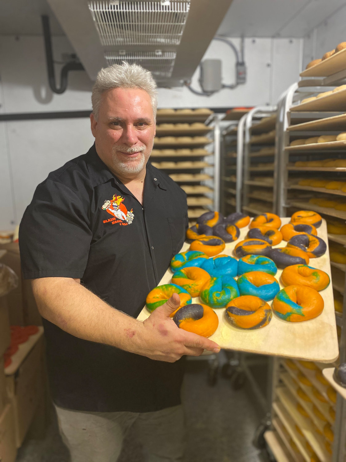 Dan Fusaro holding up a batch of bagels.